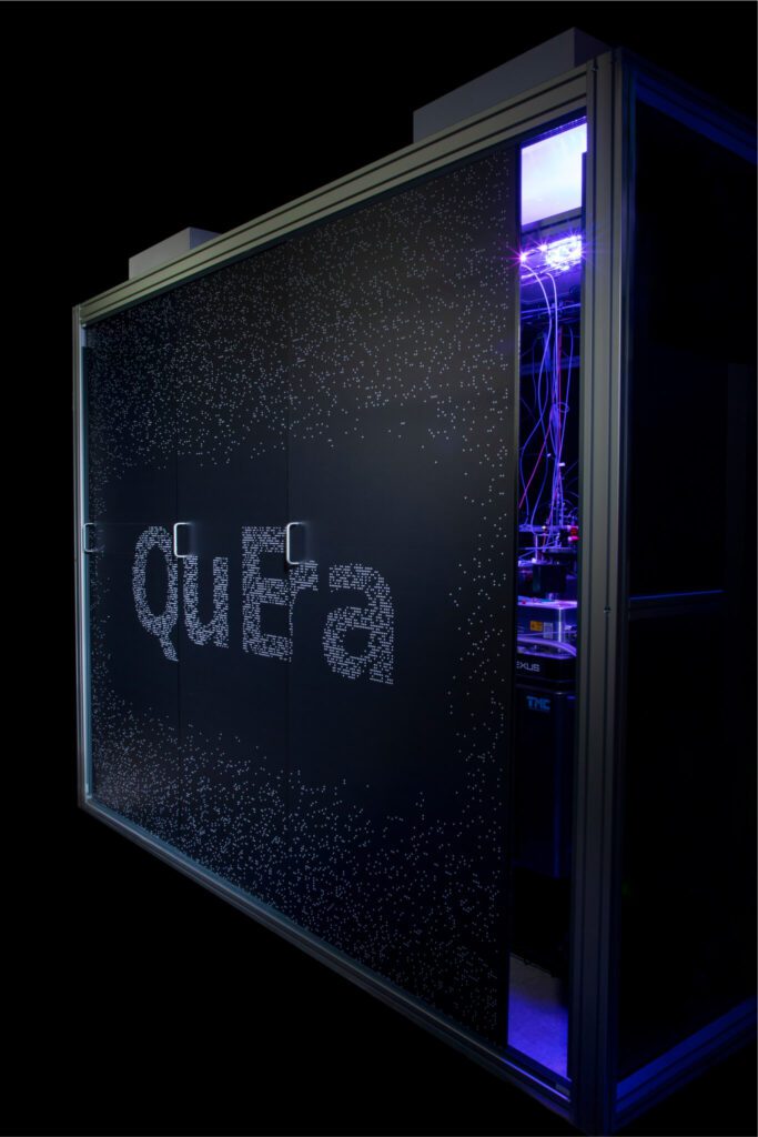 A large black computer, with QuEra on the outside and purple lighting and wiring on the inside.