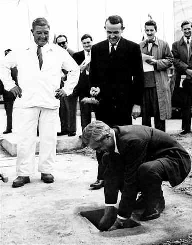 A black and white photograph showing CERN director-general Felix Bloch laying the foundation stone on the Laboratory site in 1955.