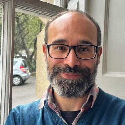 A headshot of Mustafa Rampuri, business director at Duality Quantum Photonics, standing in front of a window.