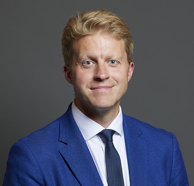 A headshot of Ben Spencer MP, wearing a blue suit.