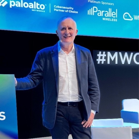 A photo of Dr Doug Pulley, standing on a stage against a podium.