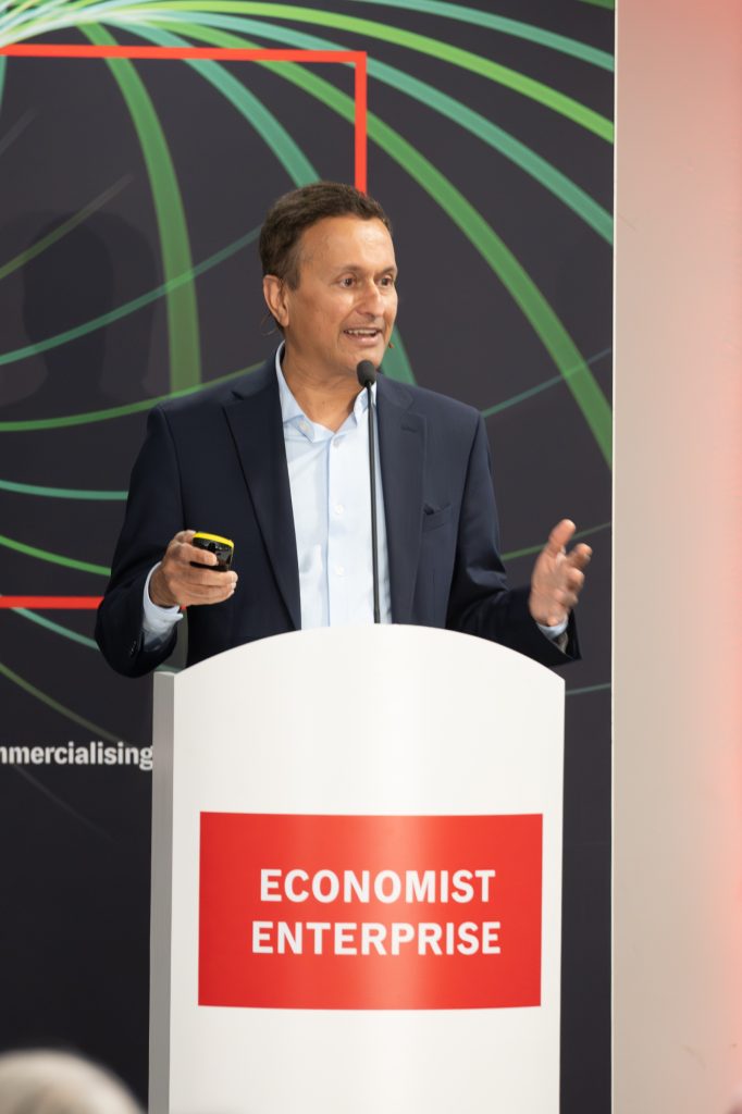 Bijoy Sagar of Bayer AG speaking in front of a lectern that says "Economist Enterprise".